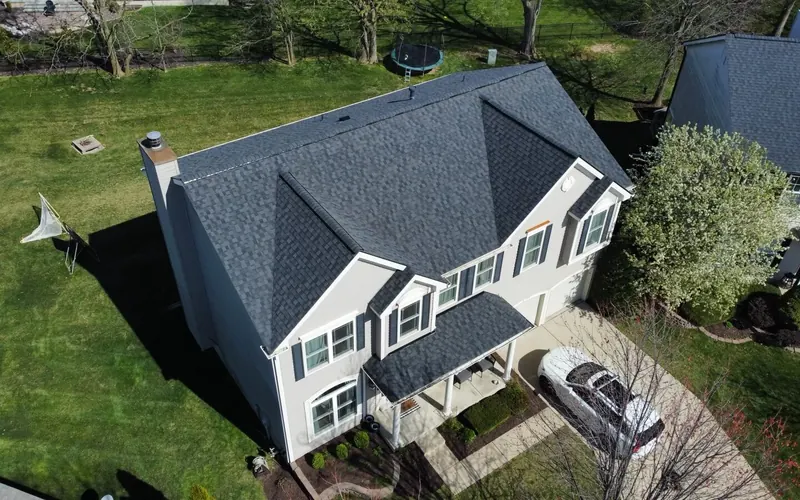 Aerial view of a two-story home with a new dark shingle roof