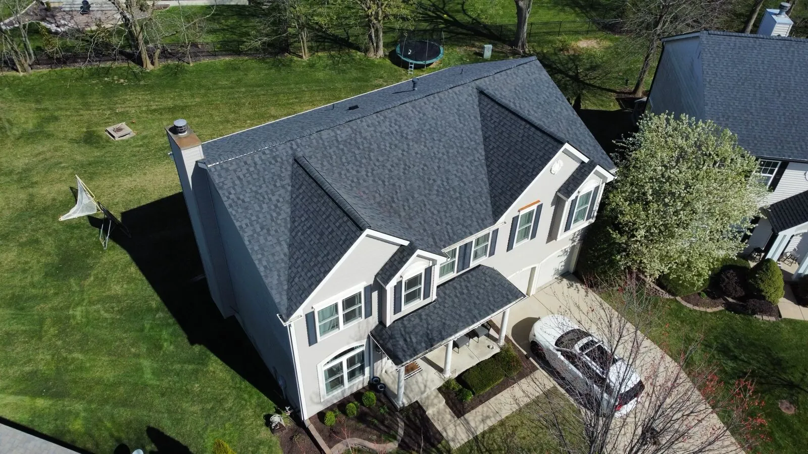 Aerial view of a two-story home with a new dark shingle roof