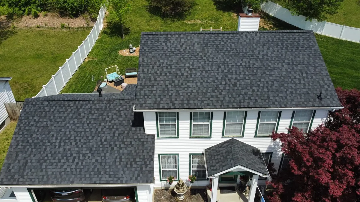 White colonial home with a new charcoal architectural shingle roof