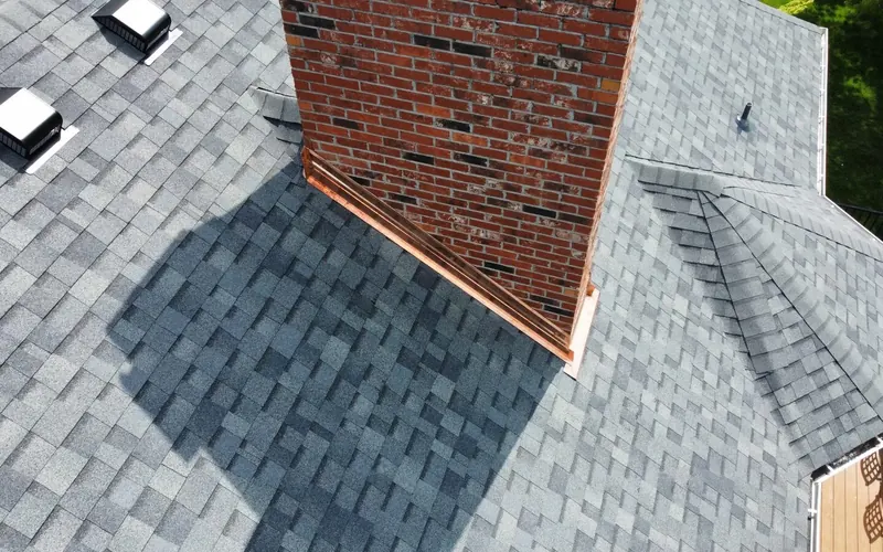 Close-up of architectural shingles, roof vents and chimney flashing