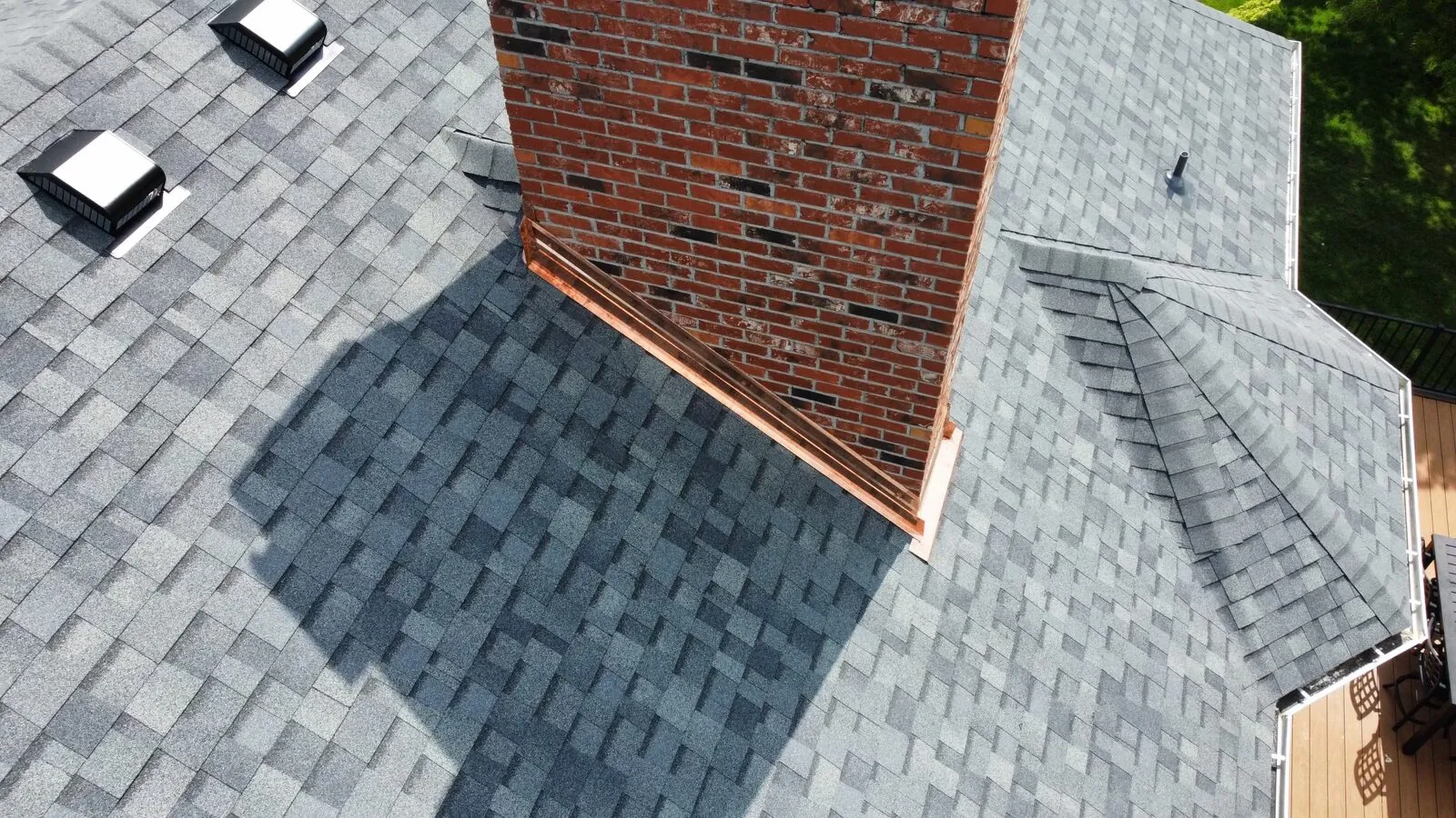 Close-up of architectural shingles, roof vents and chimney flashing
